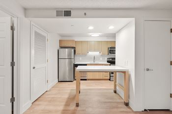 A kitchen with a white countertop and wooden cabinets.